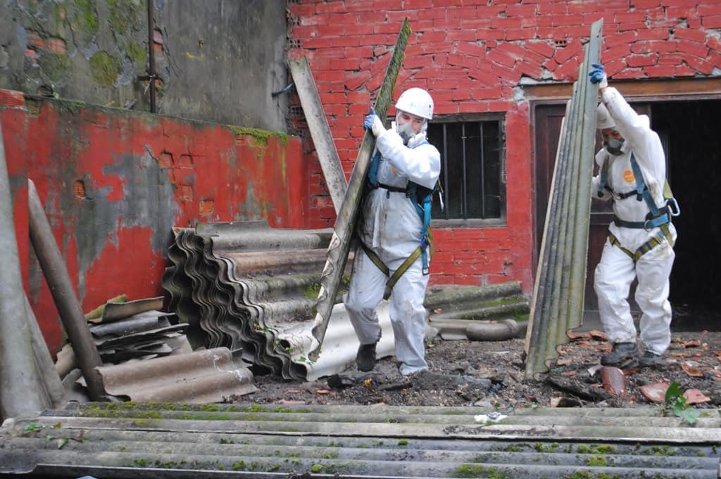 Operarios con traxe de protección retirando amianto de forma segura en Vigo